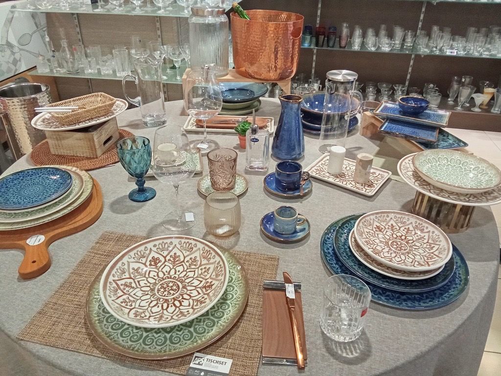 Mesa con vajilla decorada, cristalería azul y bajoplatos